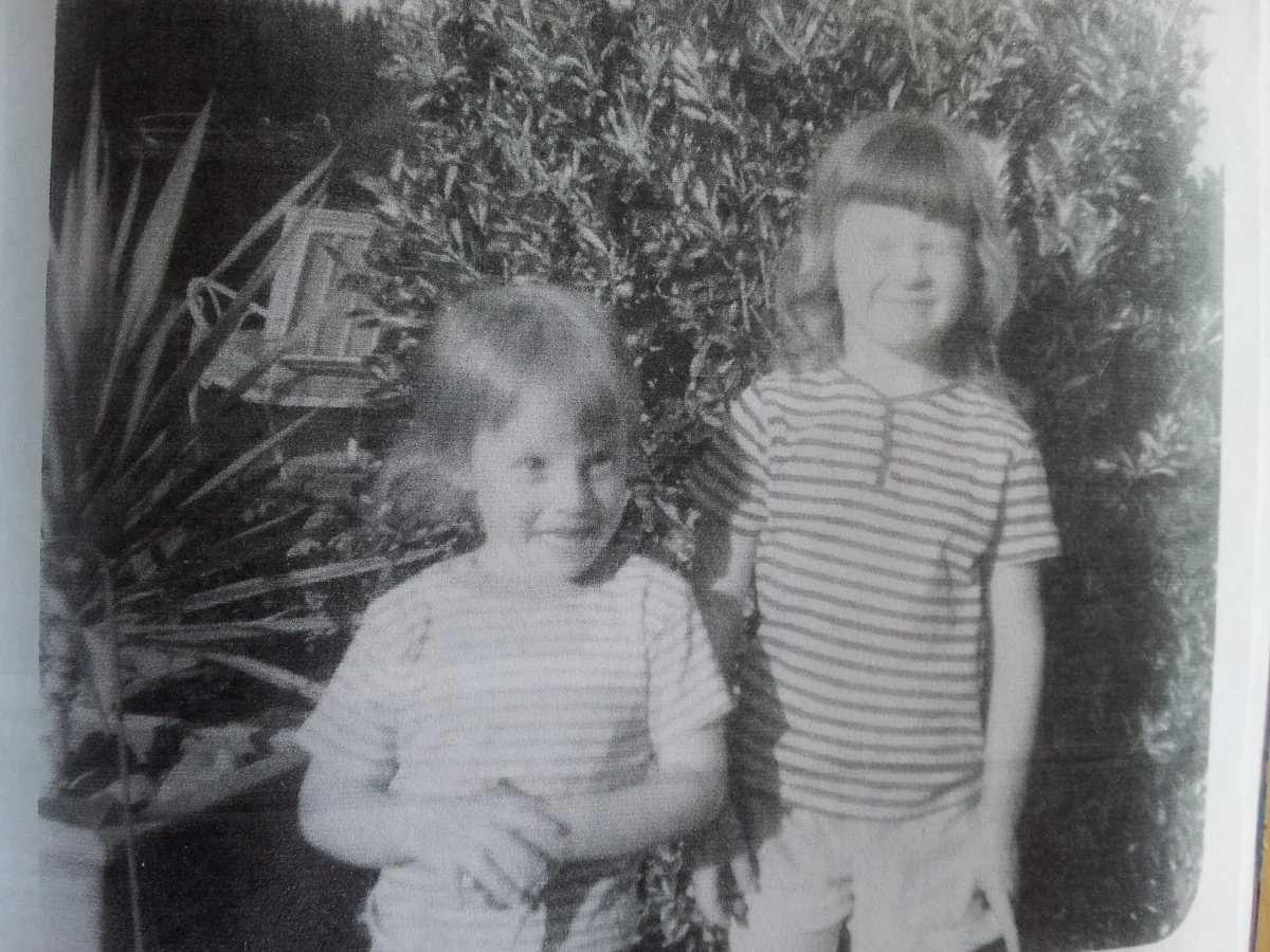 Black & white photo of two little girls wearing t-shirts and shorts